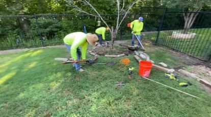 A group of people are working on a lawn.