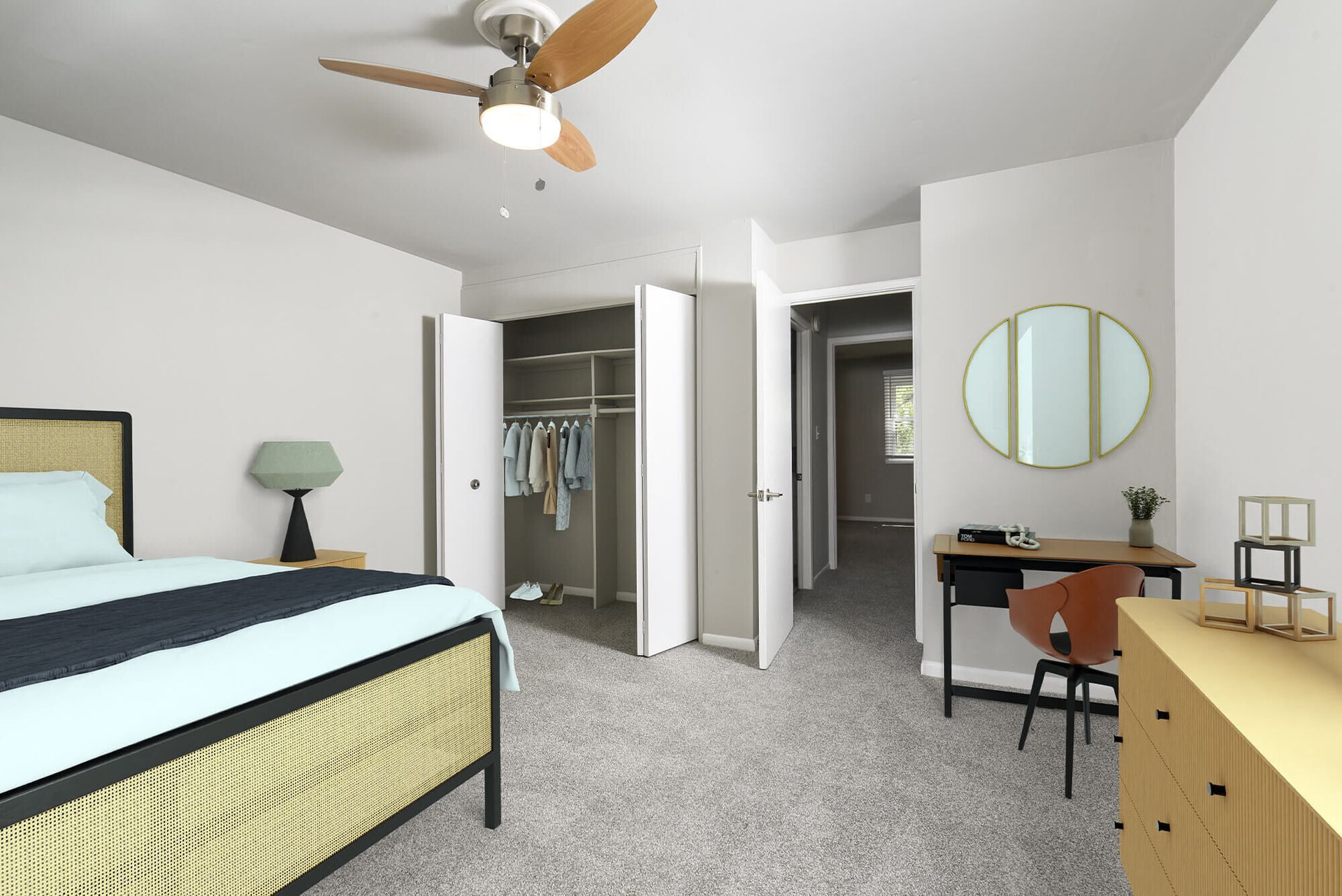 Bedroom with bed, dresser, desk, ceiling fan, and open closet.