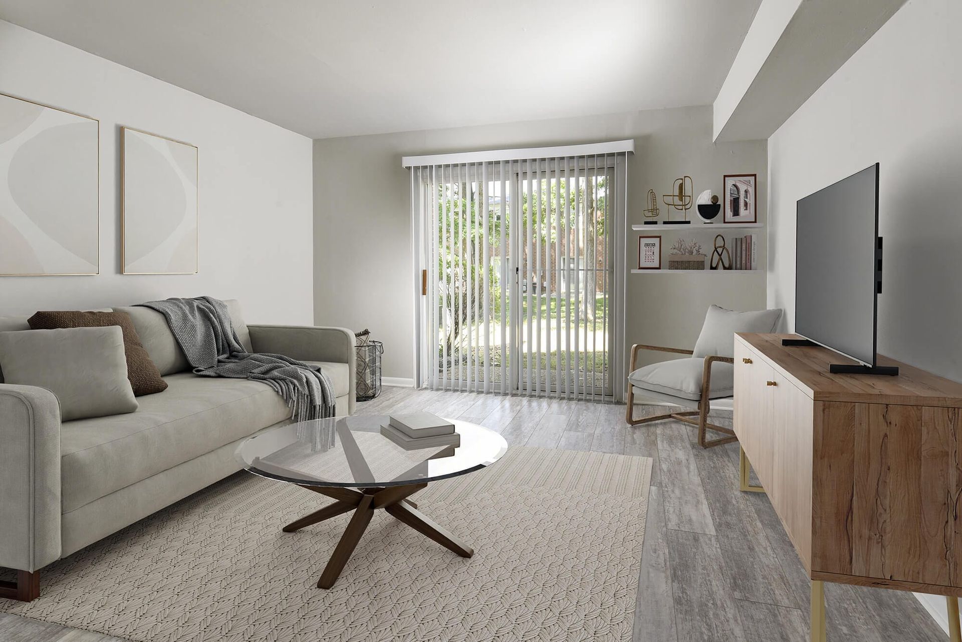 Modern apartment living room with beige sofa, glass coffee table, TV, and sliding glass door with blinds.