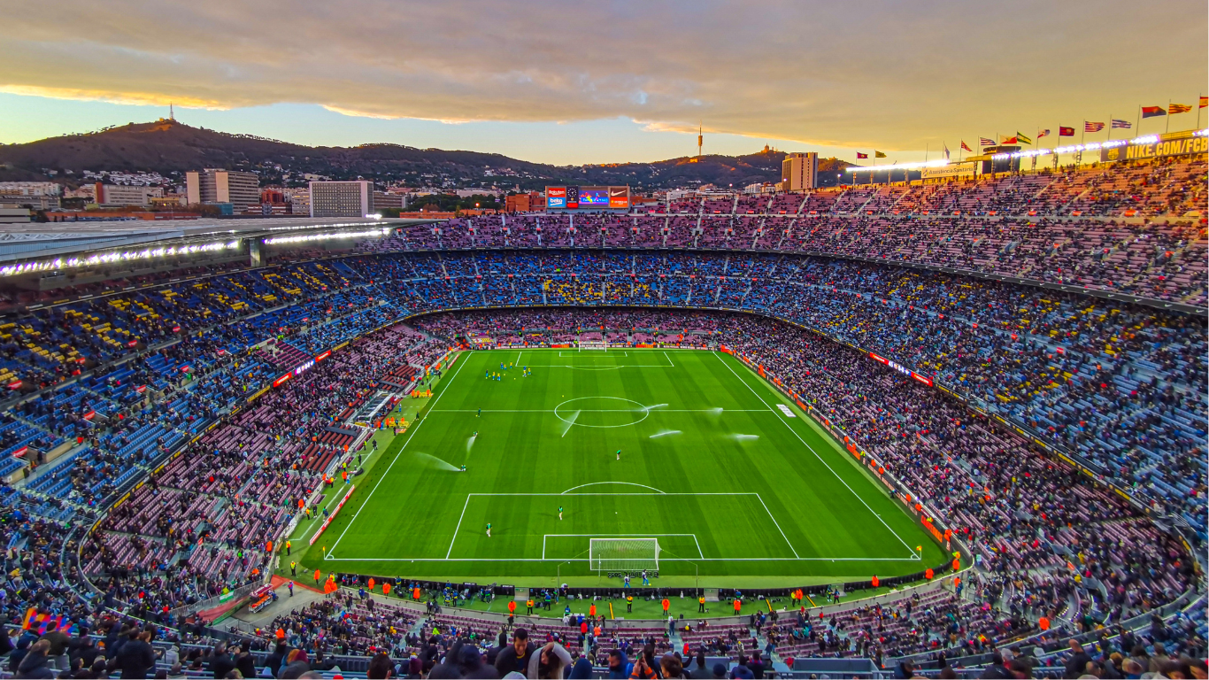 An aerial view of a soccer stadium filled with people watching a game.