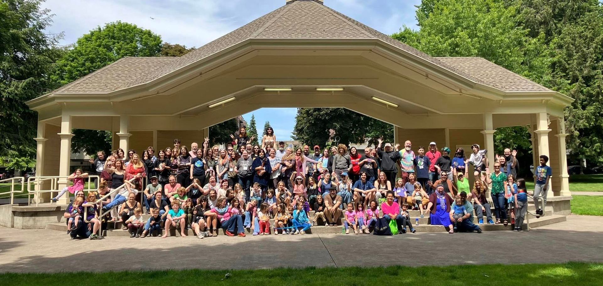 The LIFE is Good Unschooling Conference community posing for a picture in front of a gazebo in a park.