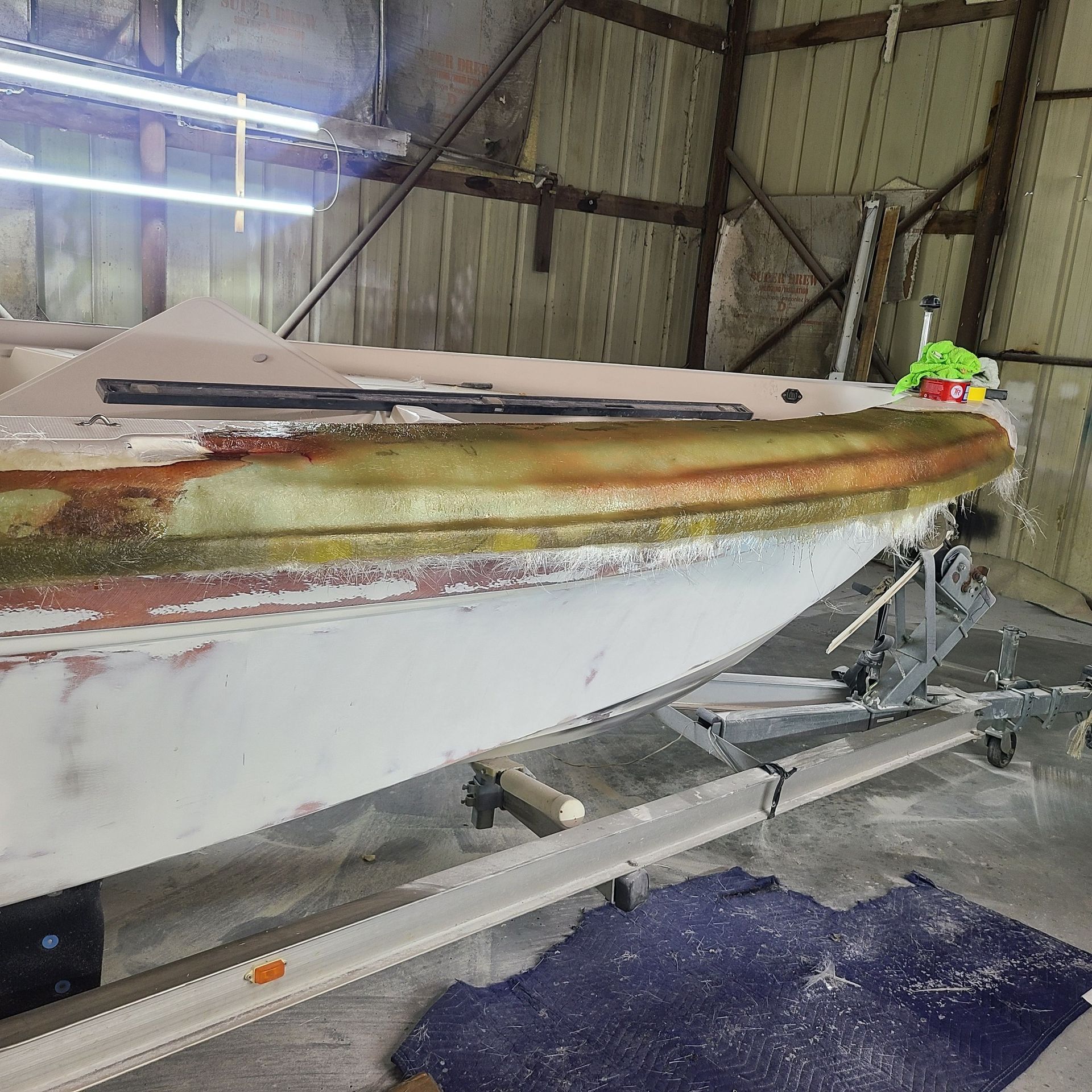 A boat is sitting on a trailer in a garage.