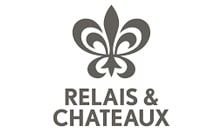 Gray Relais & Châteaux logo with a fleur-de-lis emblem above text.