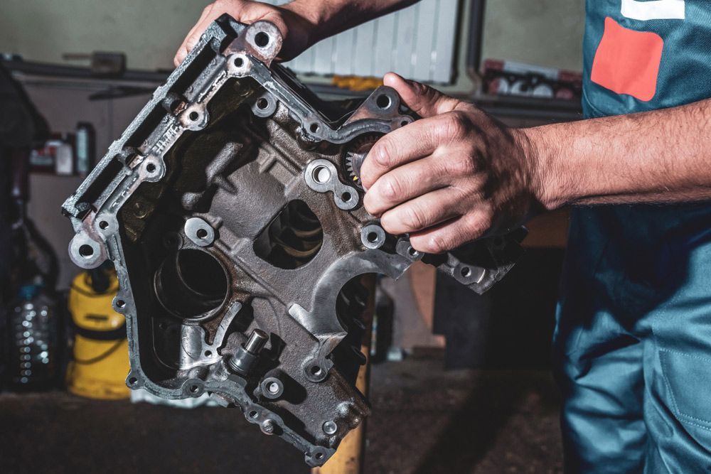 A Man Is Working On A Car Engine In A Garage — CAL AUTO Mobile Roadworthys in Woodgate, QLD