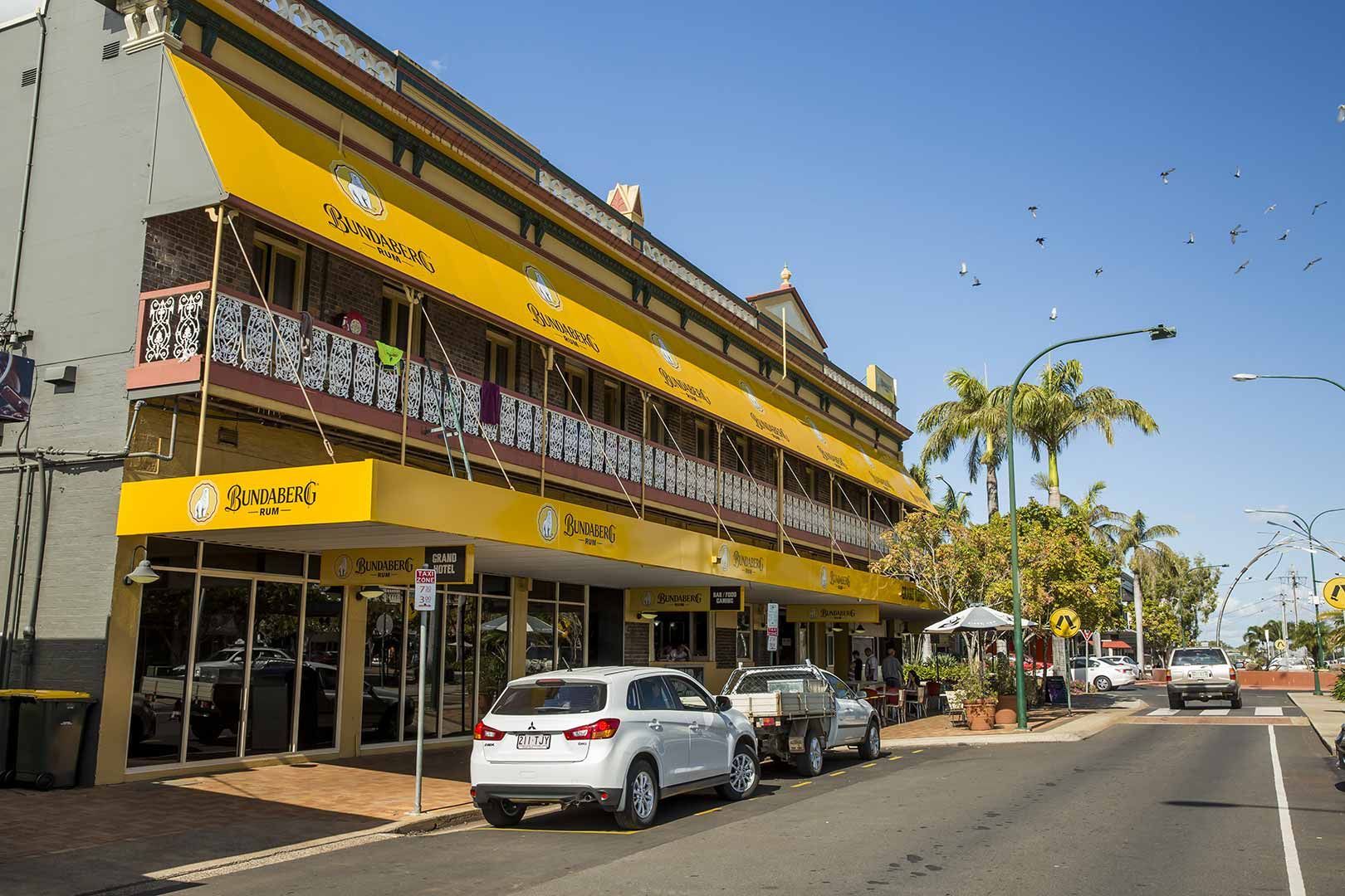 A White Suv Is Parked In Front Of A Building With A Yellow Awning — CAL AUTO Mobile Roadworthys in Bundaberg, QLD