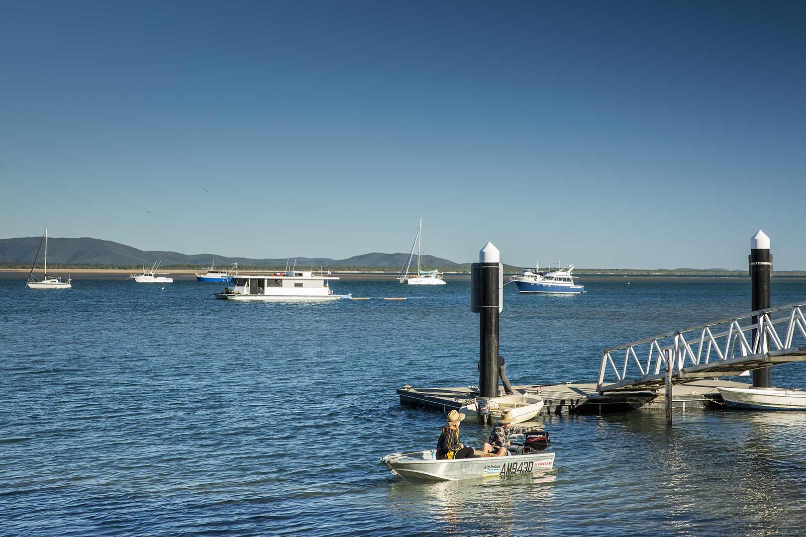 A Boat Is Docked At A Dock In The Middle Of A Body Of Water — CAL AUTO Mobile Roadworthys in Bundaberg, QLD
