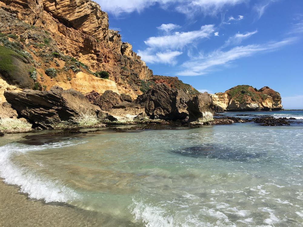 A Beach With A Lot Of Rocks And Waves Coming In — CAL AUTO Mobile Roadworthys in Childers, QLD