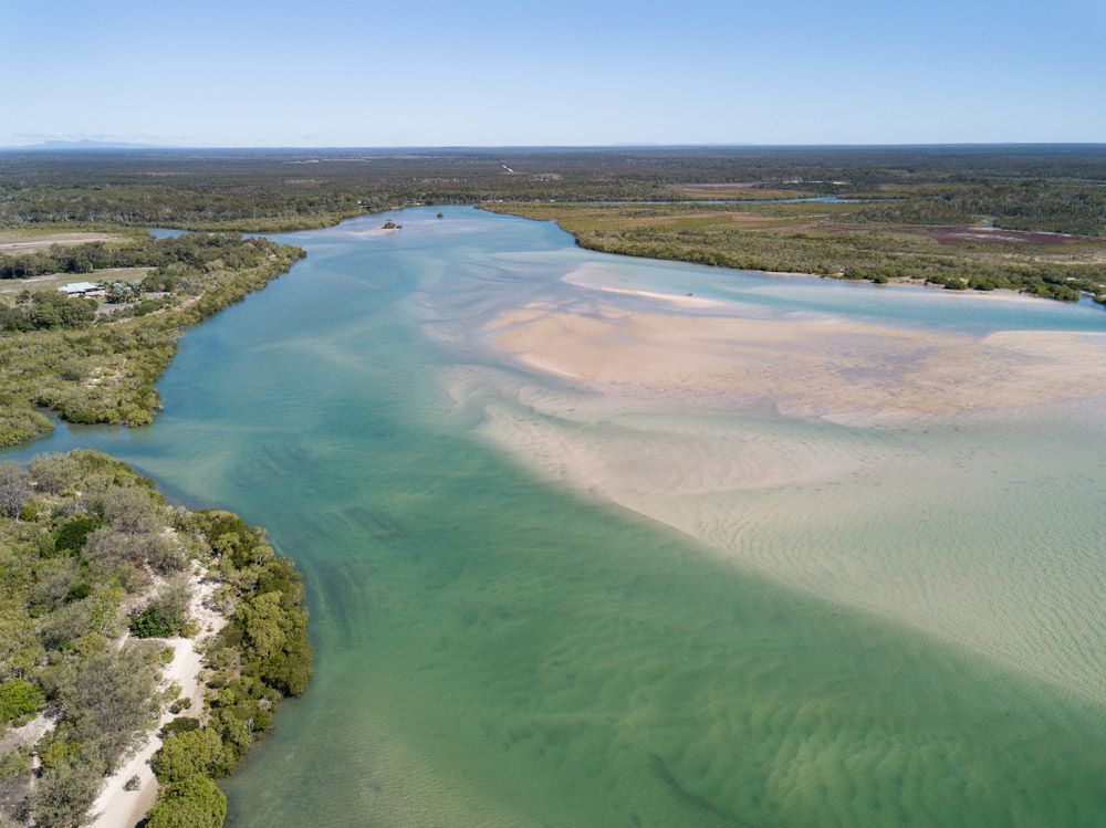 An Aerial View Of A River Flowing Through A Lush Green Forest — CAL AUTO Mobile Roadworthys in Woodgate, QLD