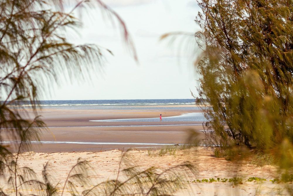 A Person Is Standing On A Sandy Beach Near The Ocean — CAL AUTO Mobile Roadworthys in Woodgate, QLD