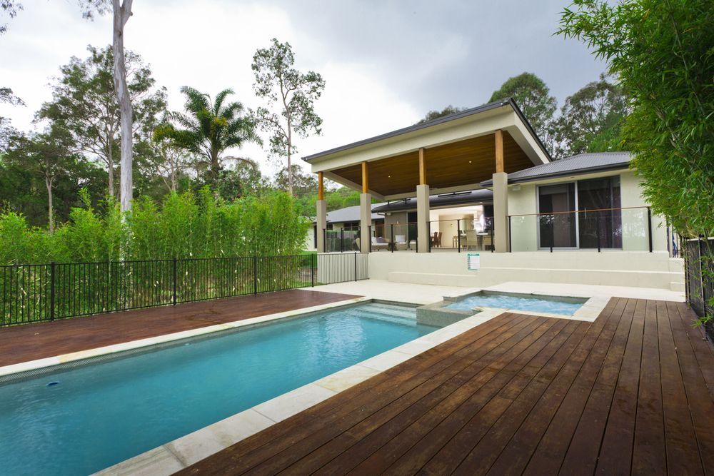 A House With a Large Swimming Pool in Front of It — MDSR Group in Brinsmead, QLD