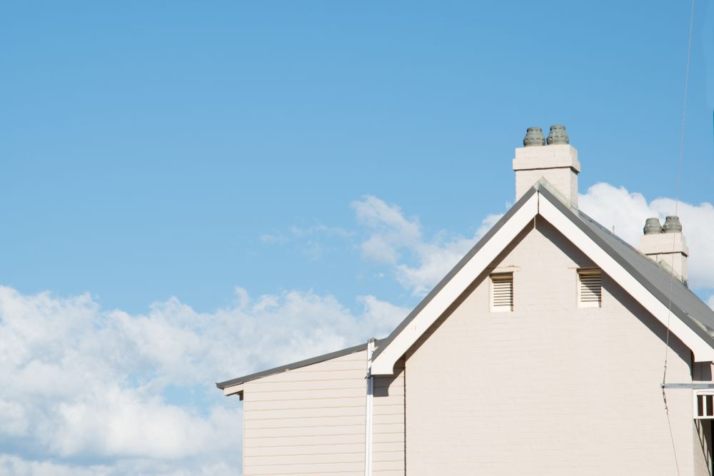 A White House With a Chimney on the Roof and a Blue Sky in the Background — MDSR Group in Redlynch, QLD