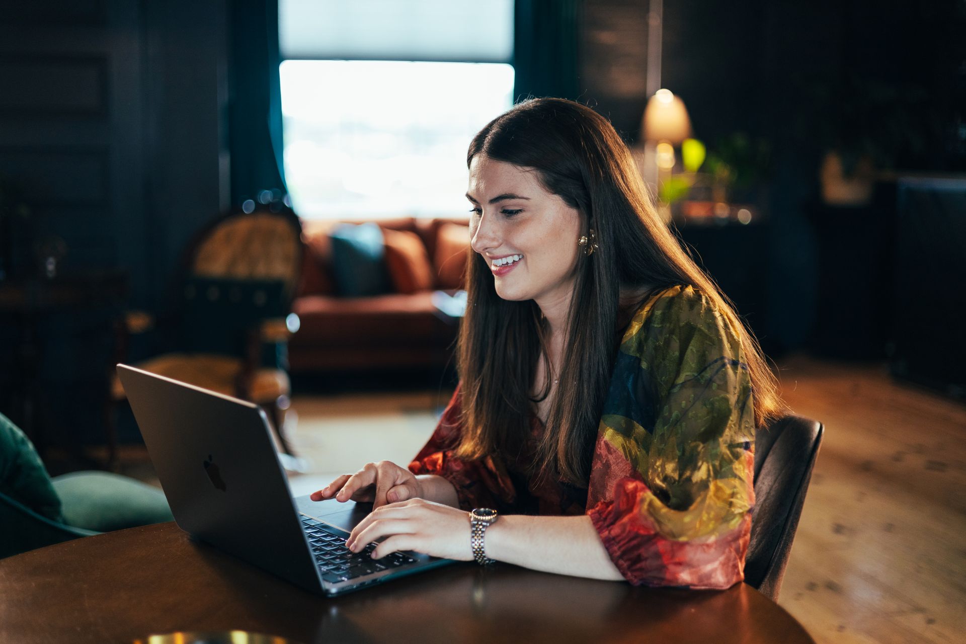 A woman is sitting in a chair in front of a laptop computer.