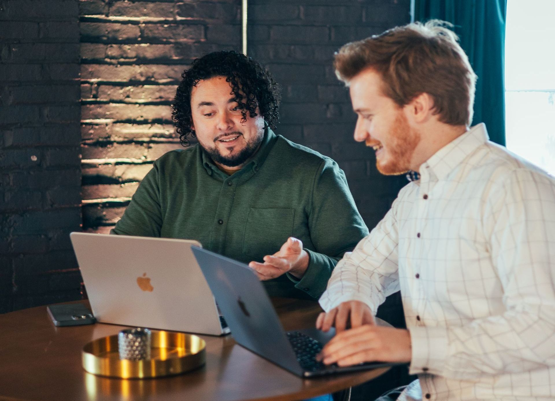 A man and a woman are sitting at a table with a laptop.