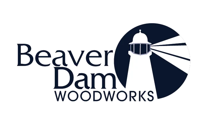 The logo for beaver dam woodworks has a lighthouse on it.