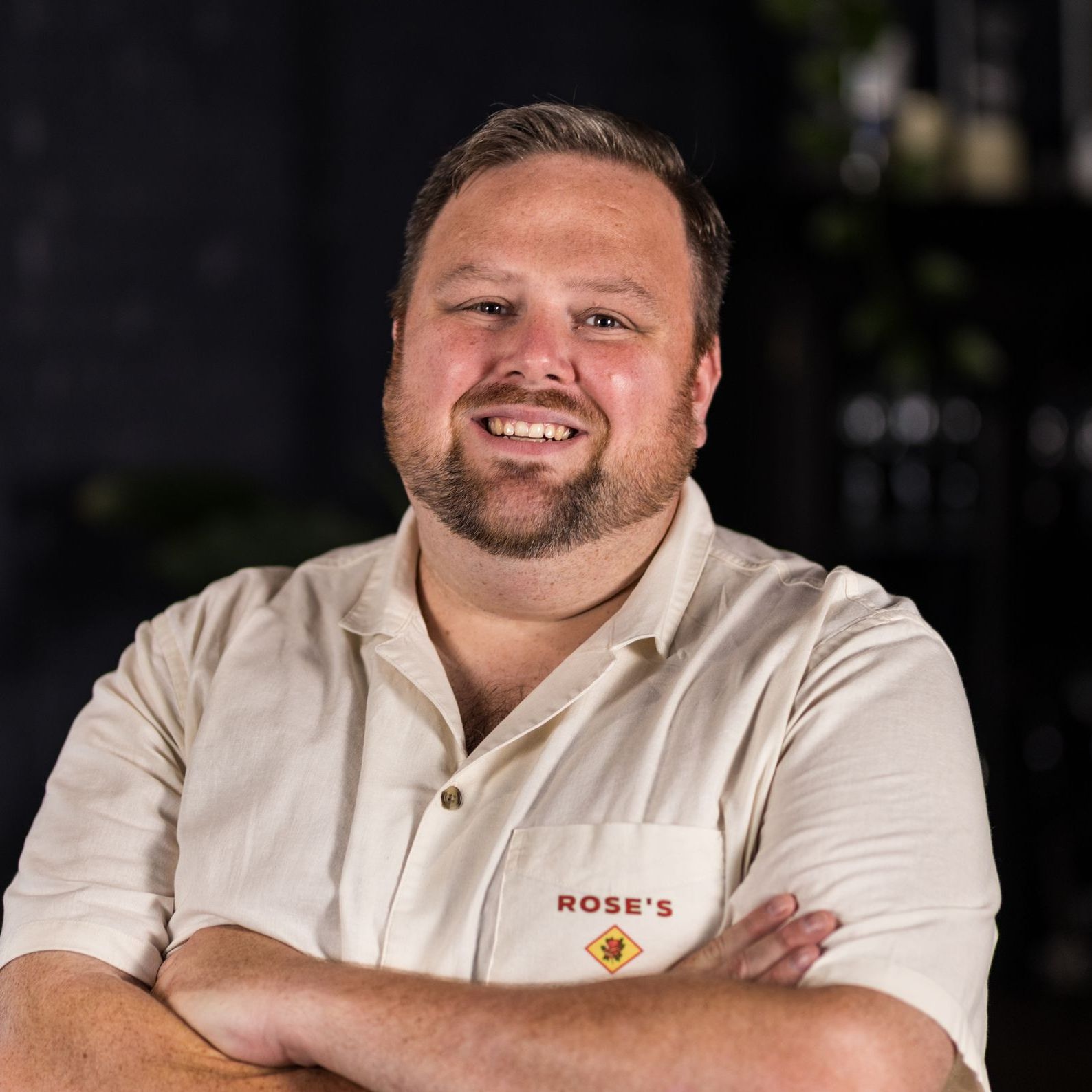A man in a grey sweater is smiling for the camera
