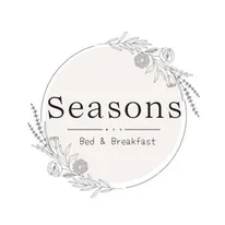 A logo for a bed and breakfast with flowers in a circle.