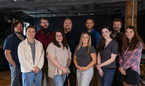 A group of people are posing for a picture together in a room.