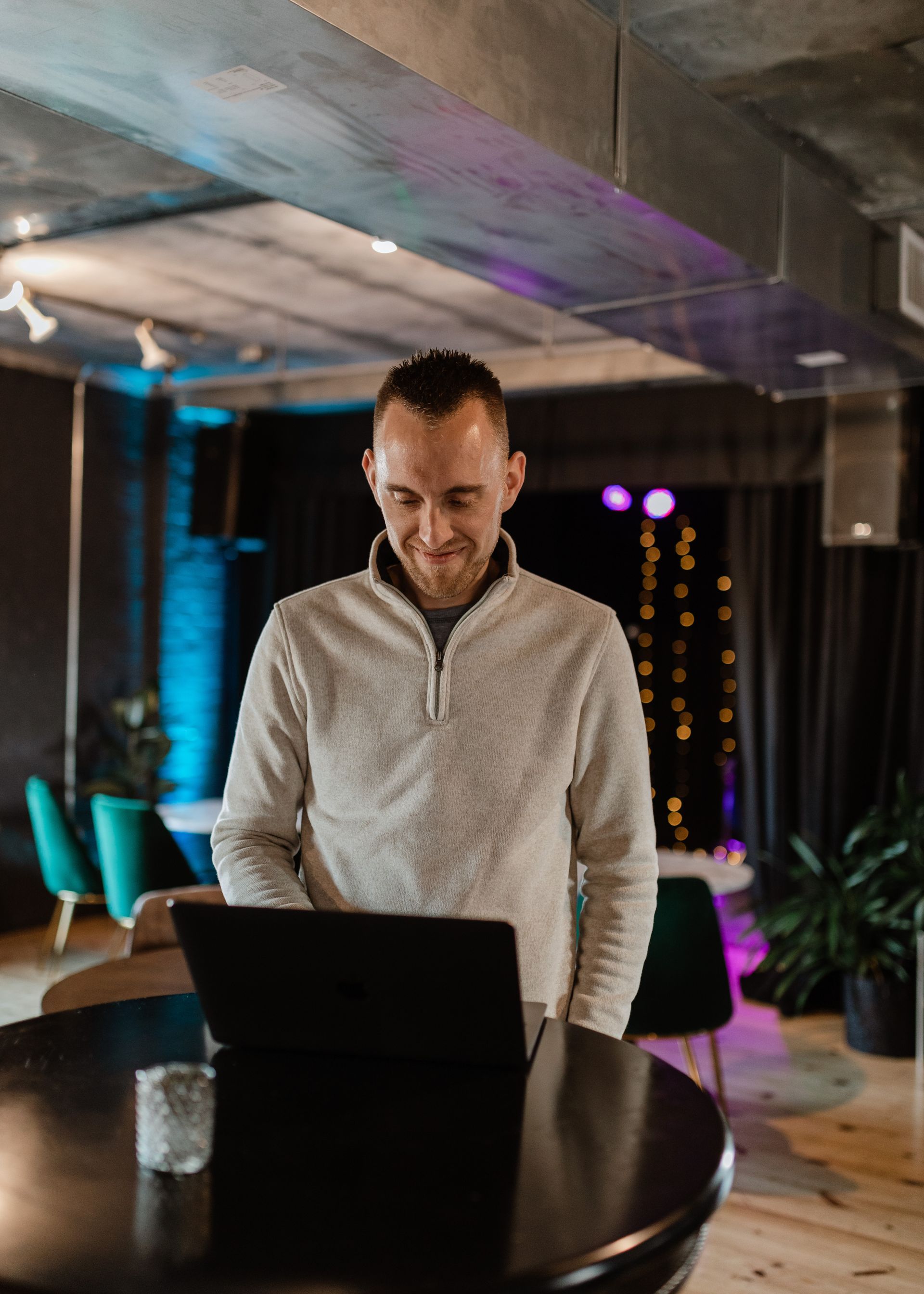 A man is standing in front of a laptop computer.