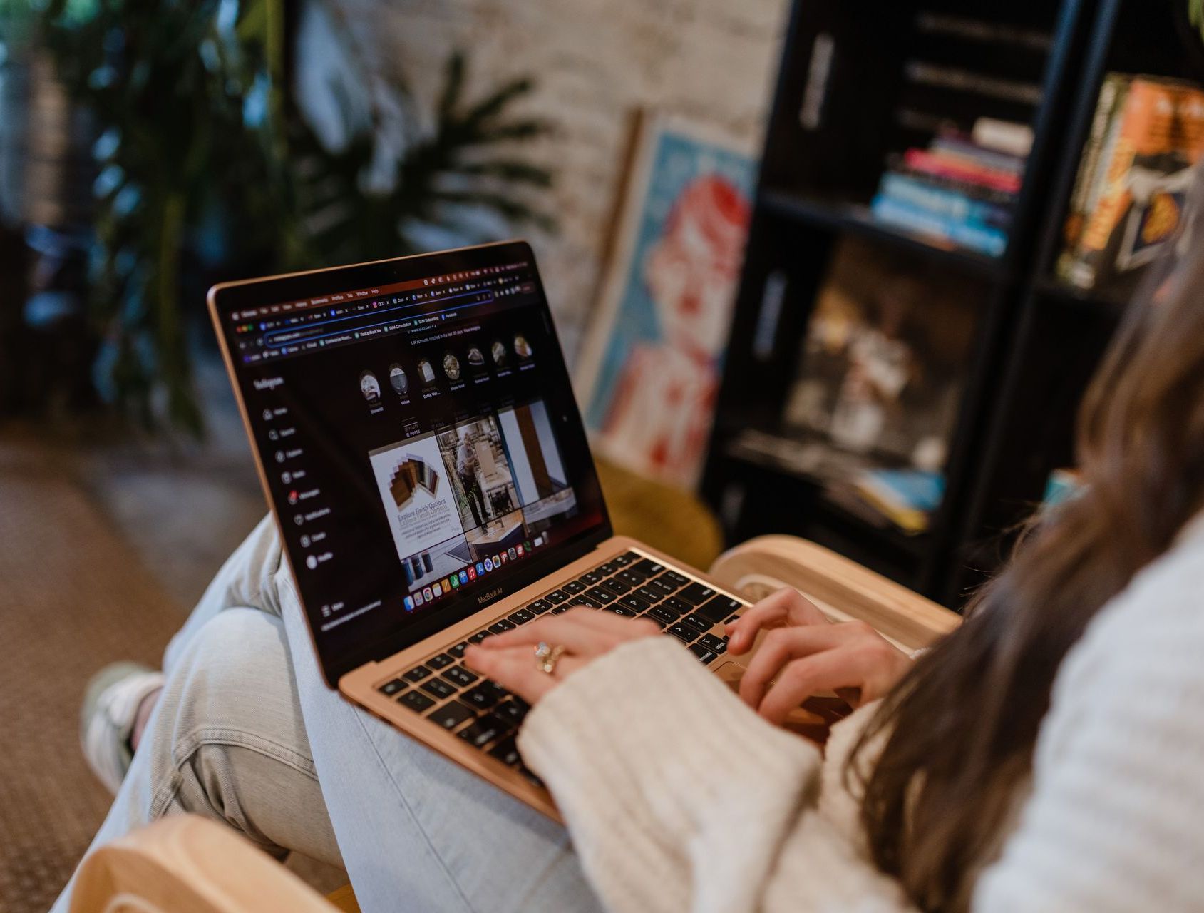 A woman is sitting in a chair using a laptop computer.