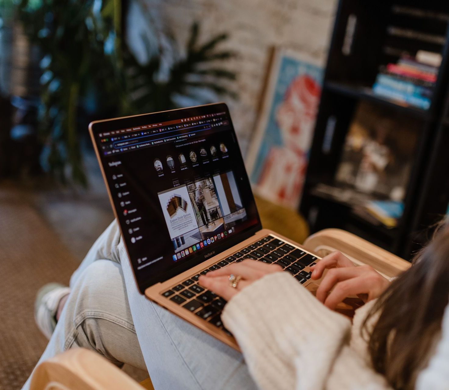 A woman is sitting in a chair using a laptop computer.