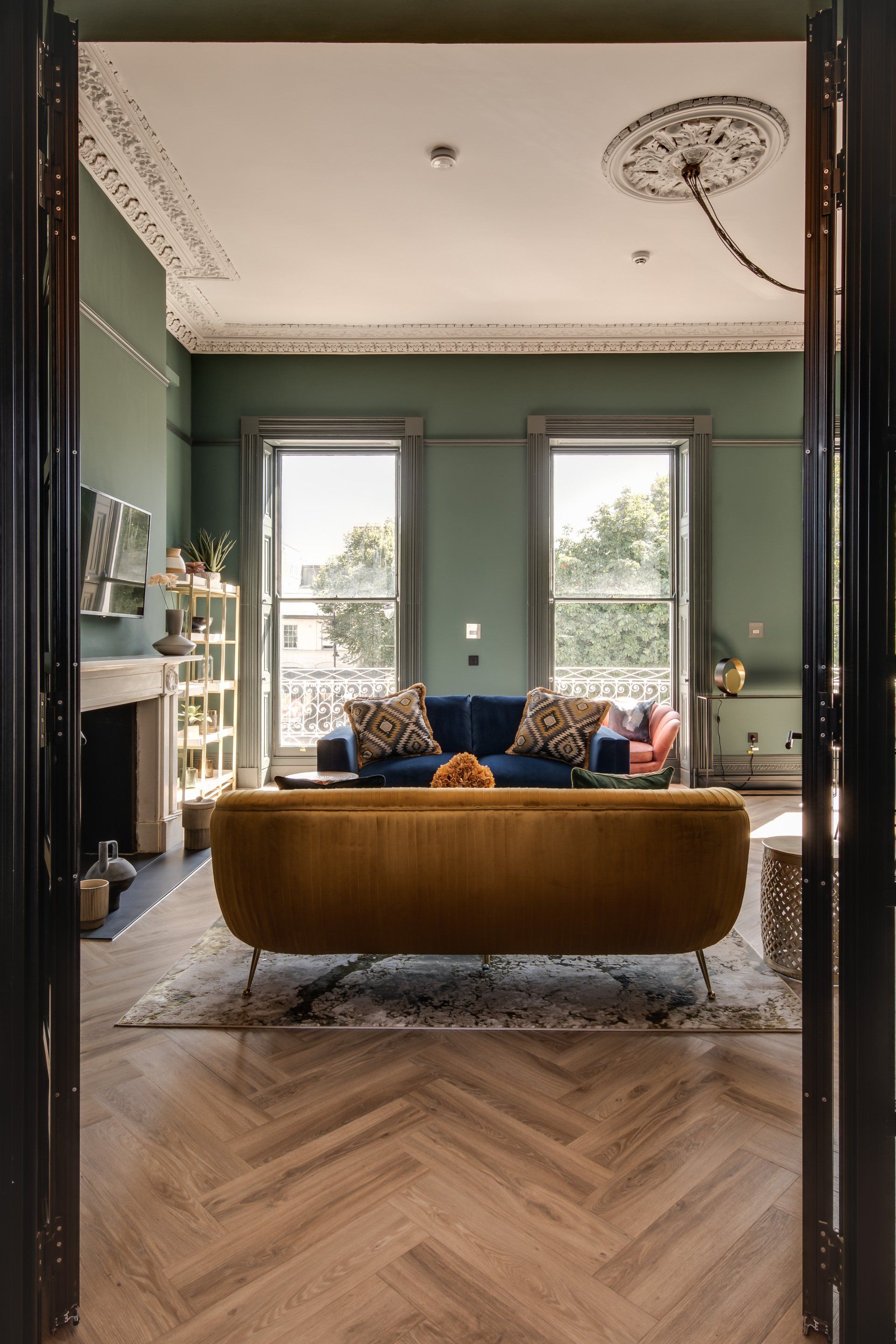A living room with a yellow couch and a blue couch