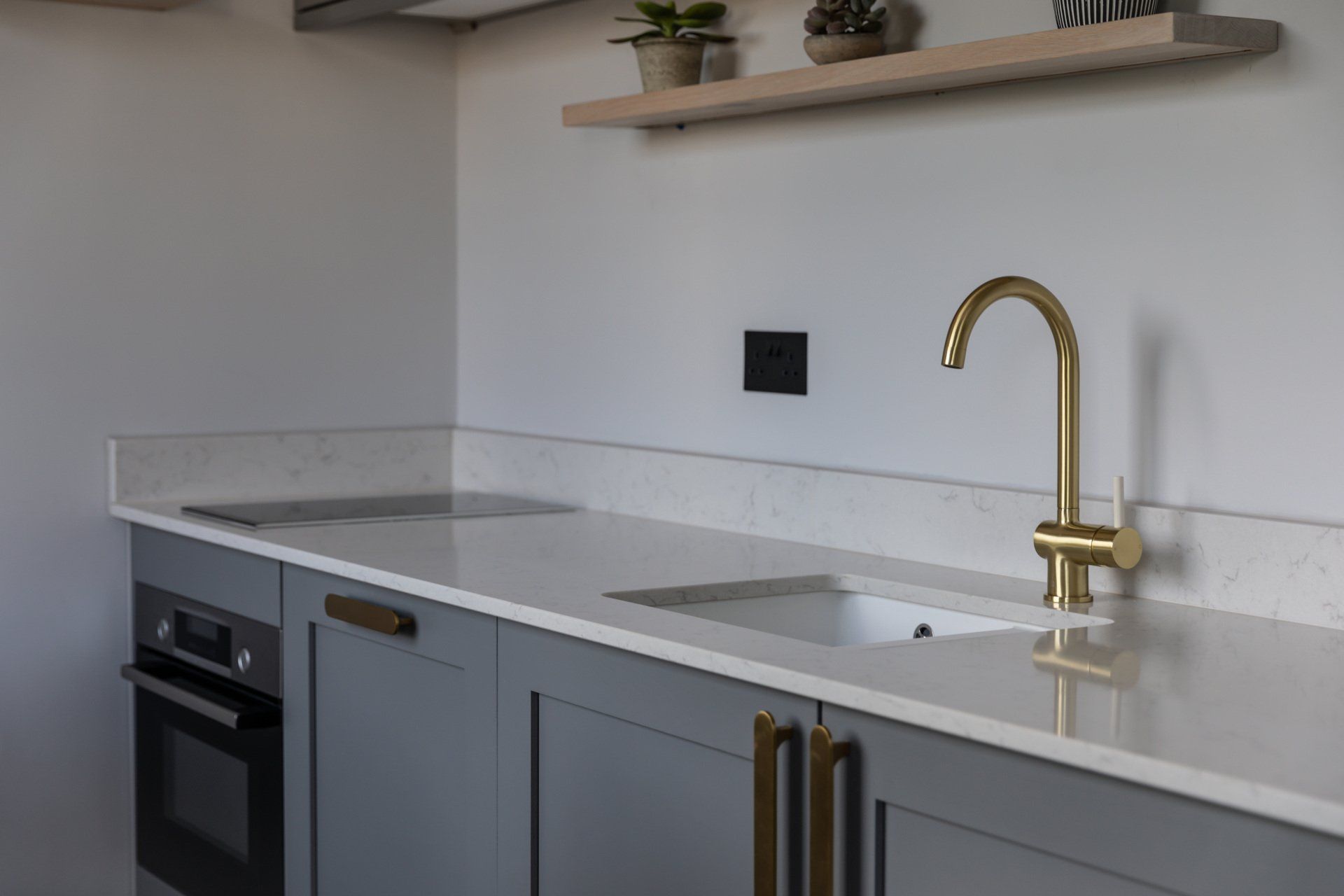 A kitchen with a sink and a stove top oven