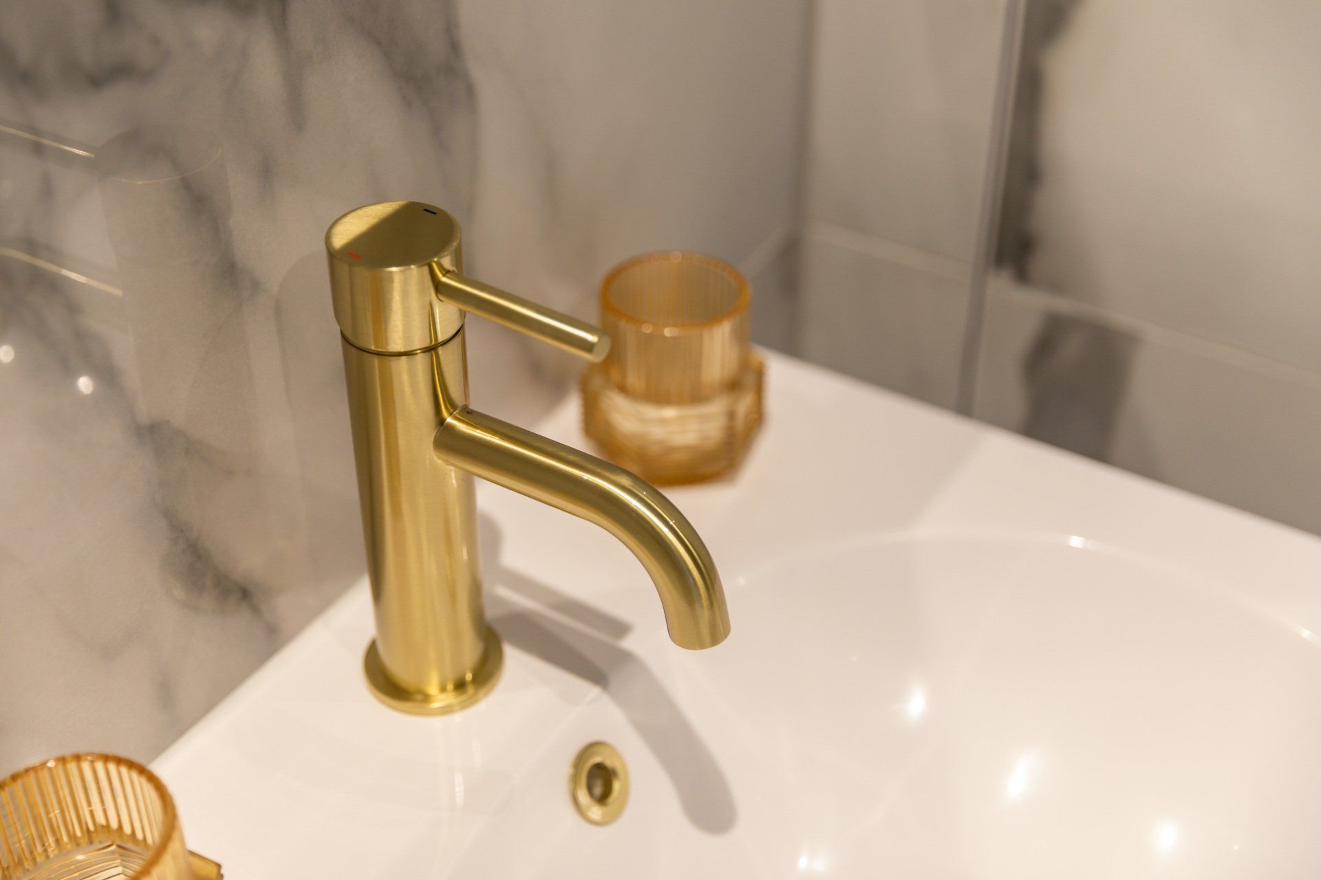 A close up of a gold faucet on a bathroom sink.
