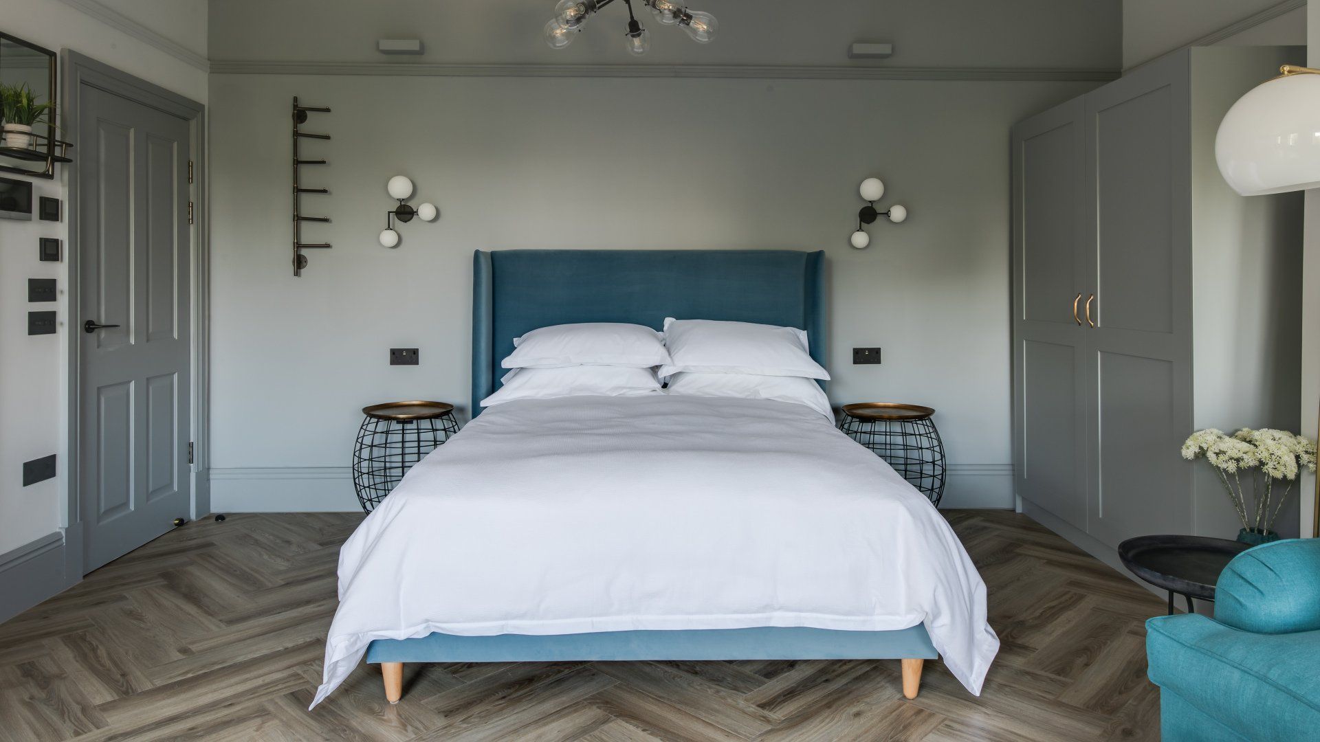 A bedroom with a bed , nightstands , and a chair.