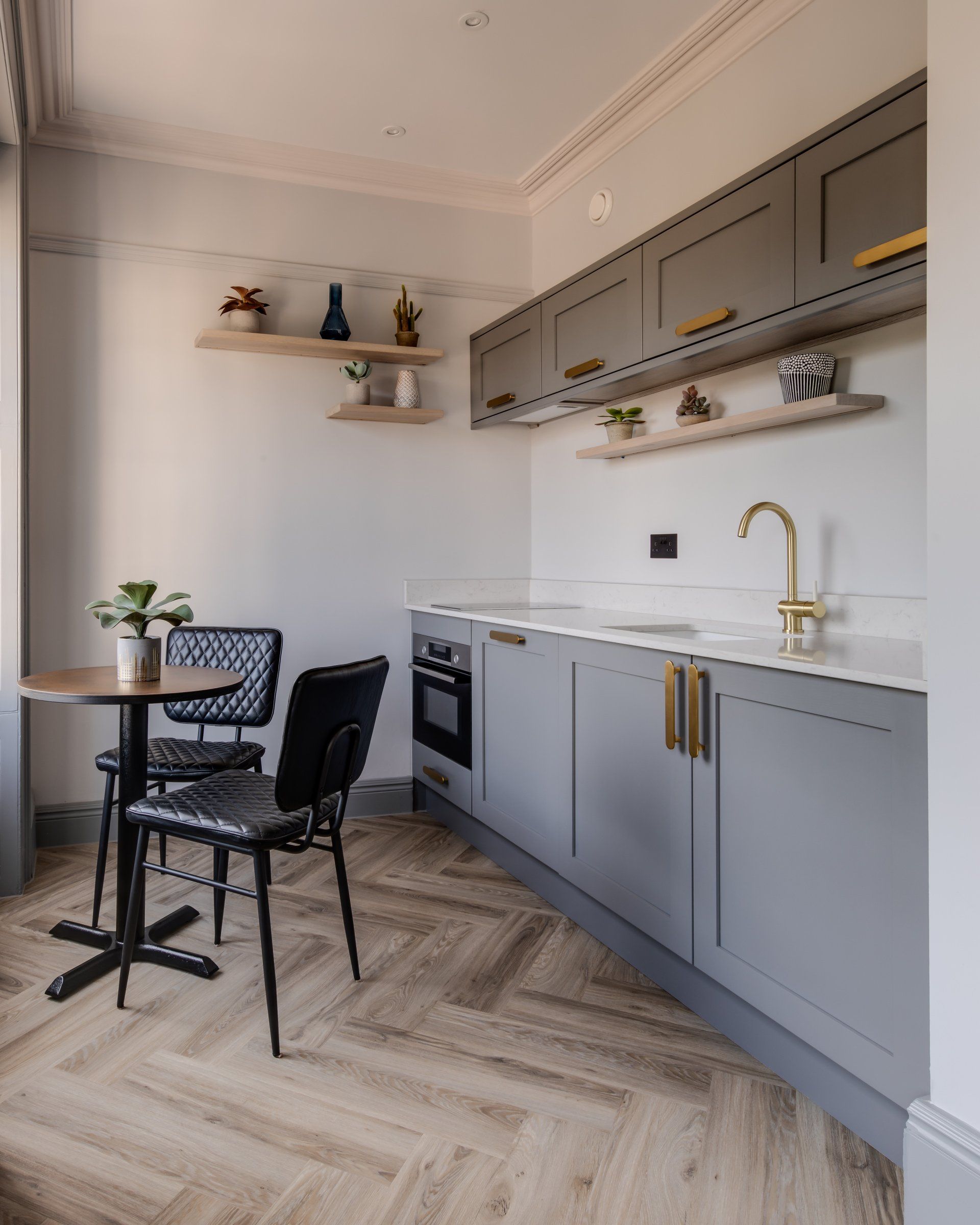 A kitchen with a table and chairs and a sink.