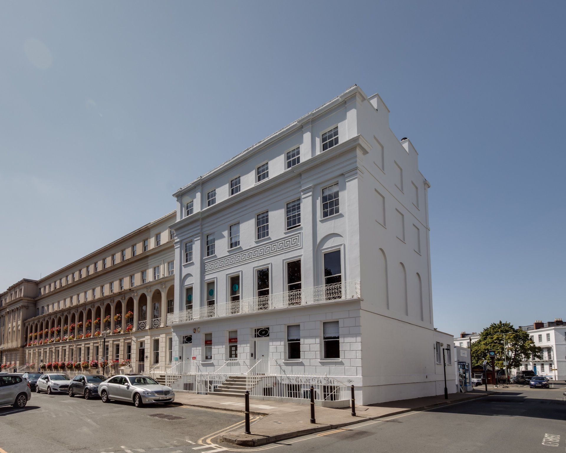 A large white building with cars parked in front of it.
