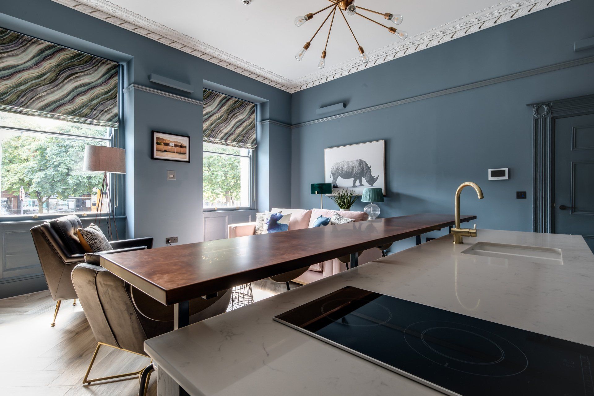 A living room with a long table and chairs and a stove top oven.