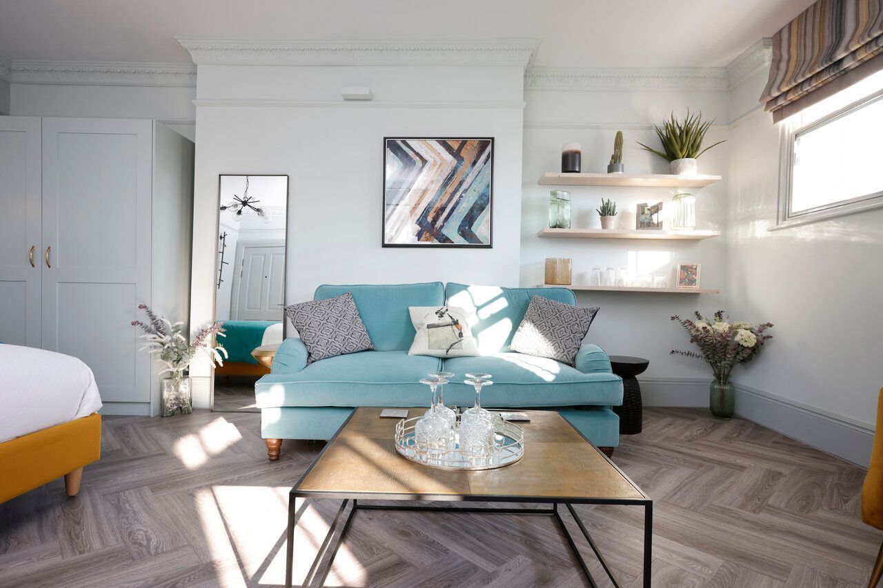 A living room with a blue couch and a coffee table.