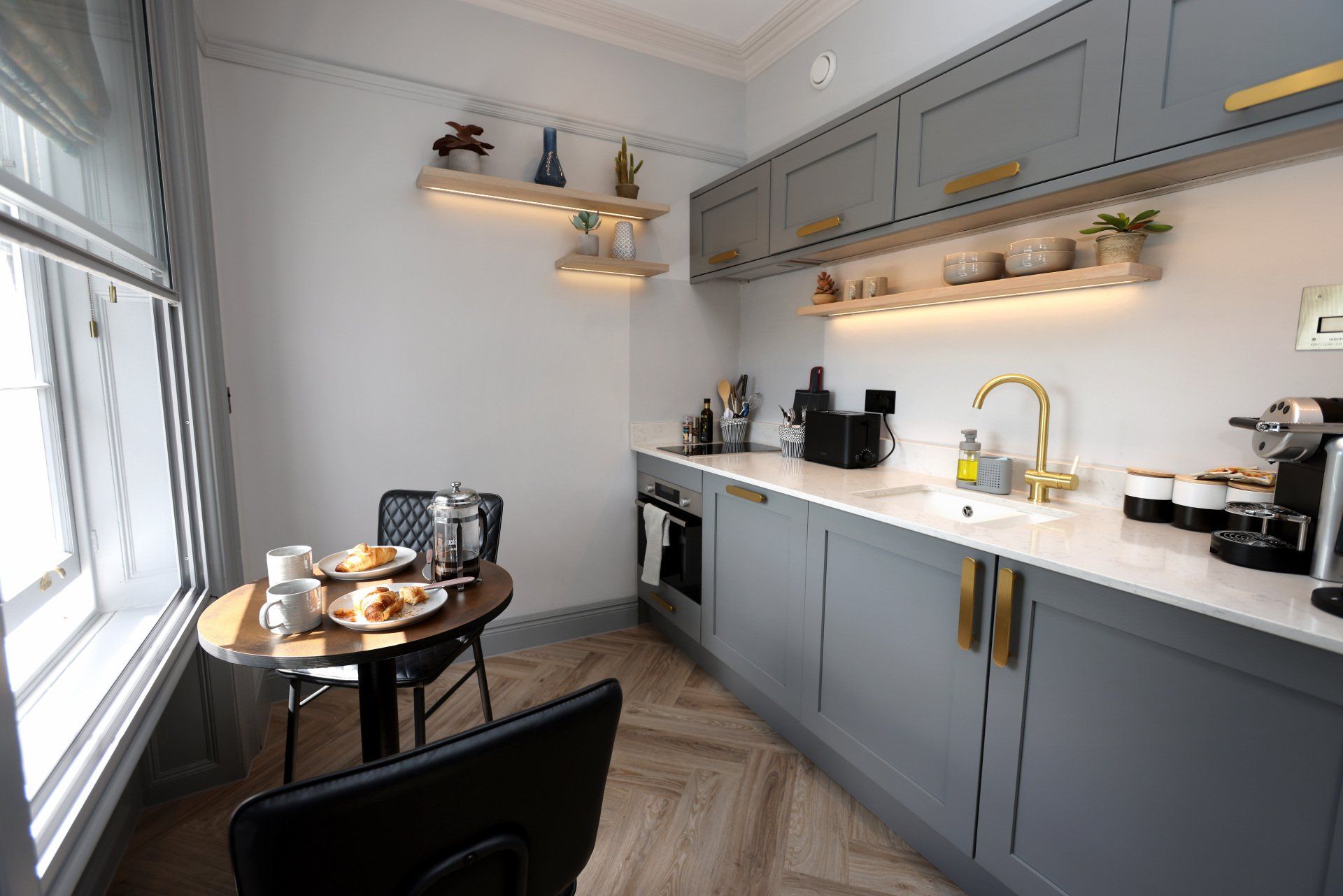 A kitchen with a table and chairs and a sink.