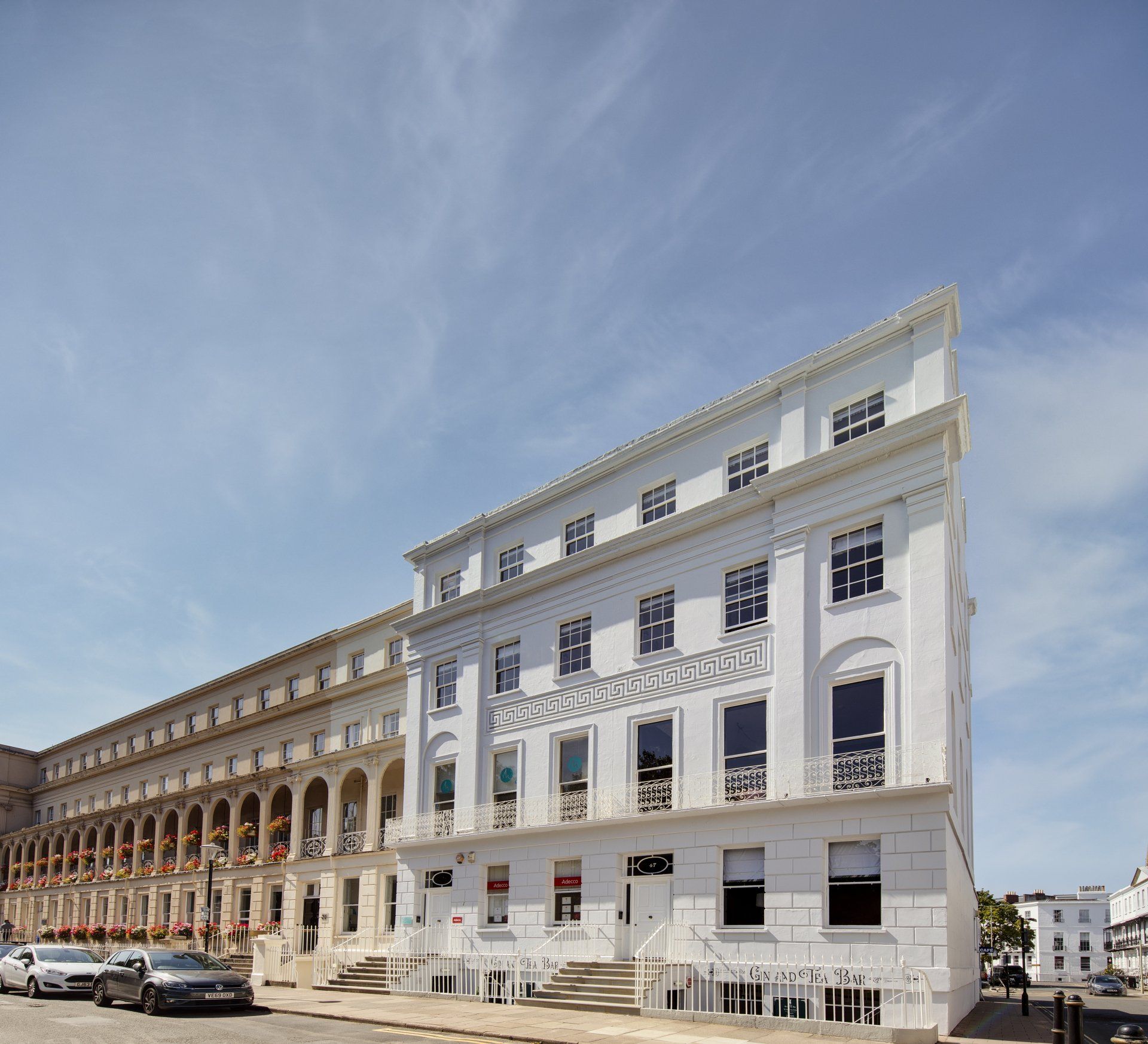A large white building with cars parked in front of it