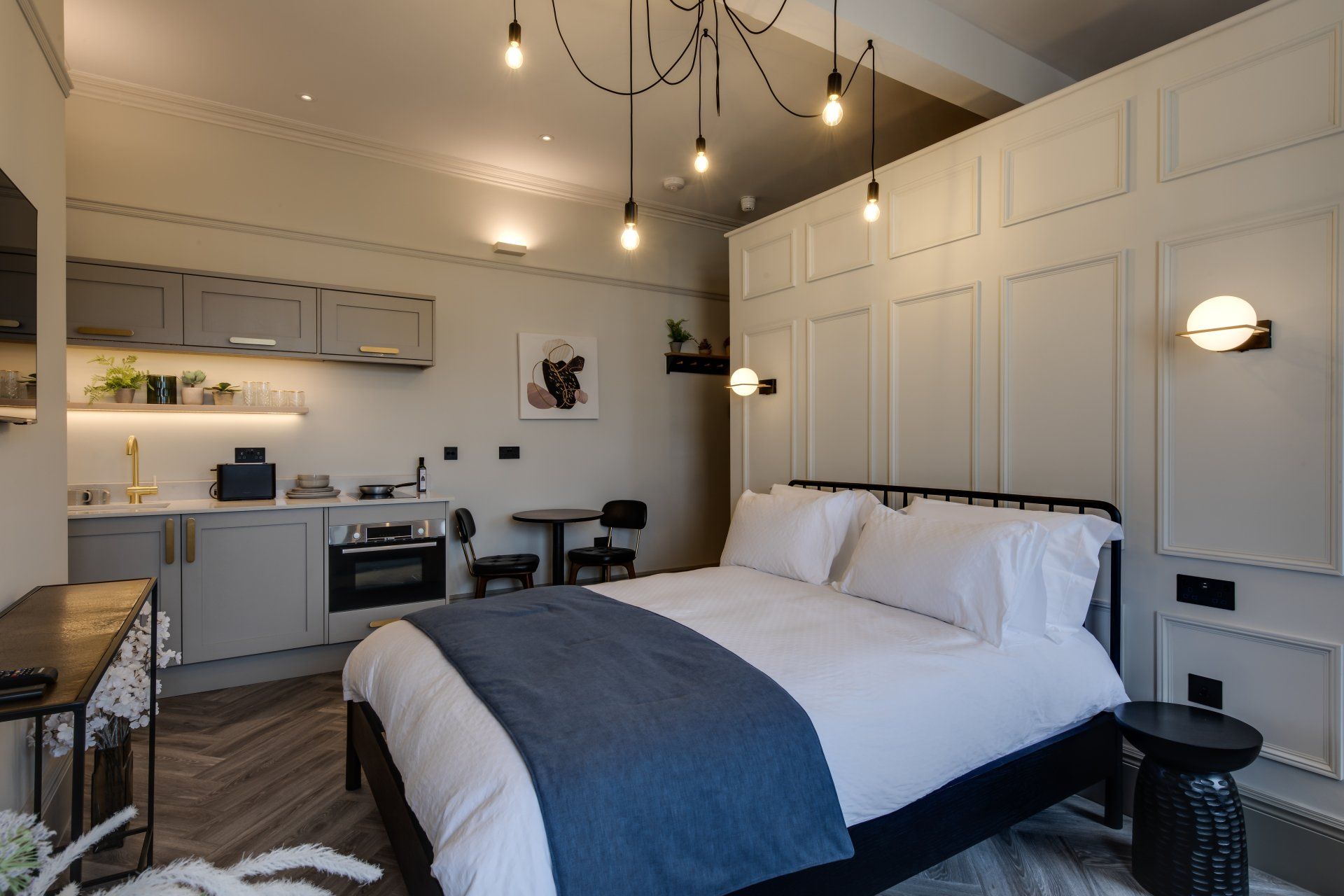 Bedroom featuring double bed with white linen and blue decor within a luxury apartment at Neptune Apartments in Cheltenham