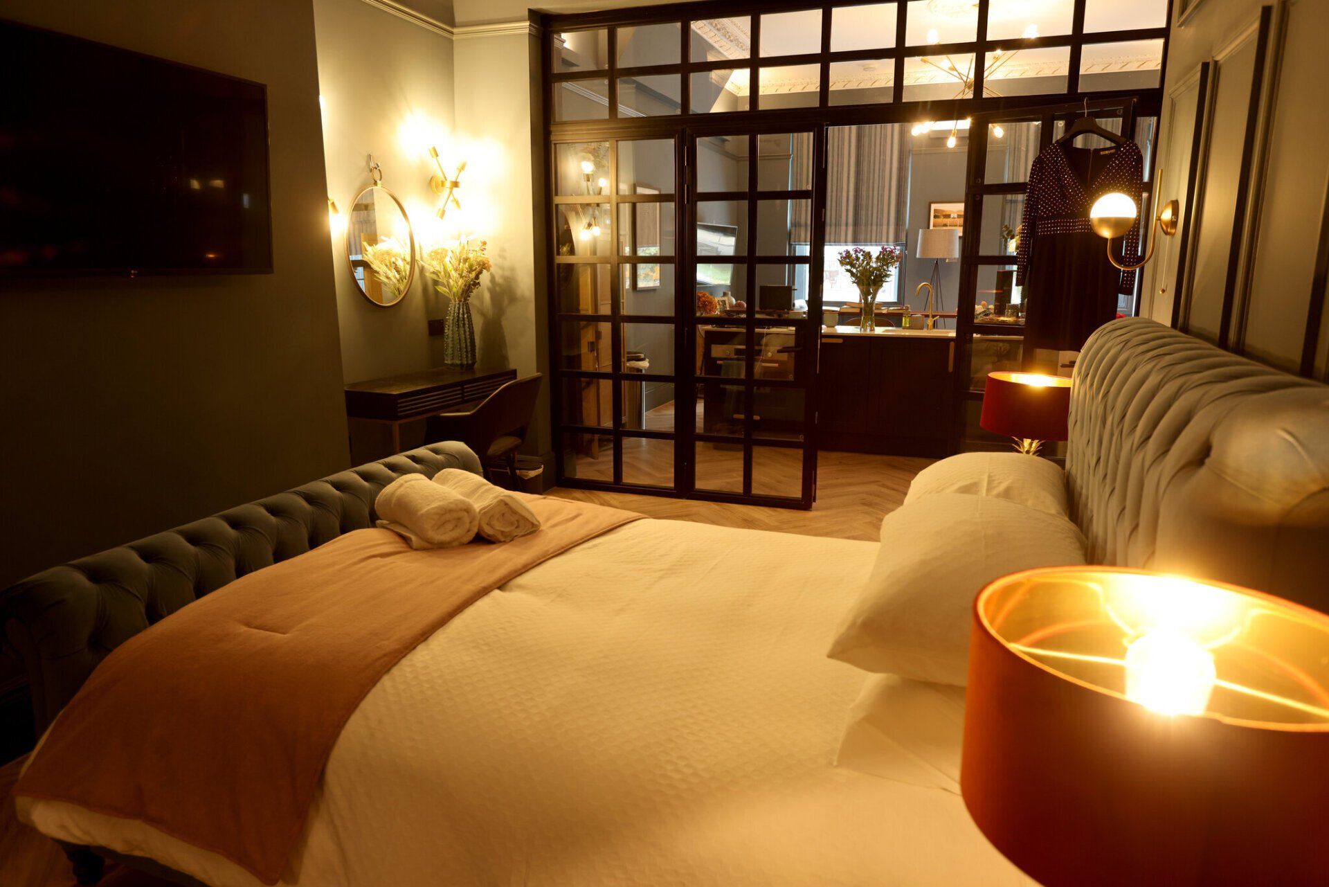 A bedroom with a large bed and two lamps