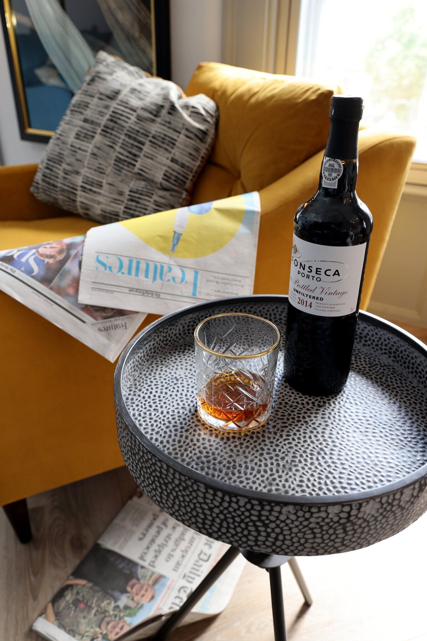 A bottle of wine is sitting on a table next to a glass of wine.