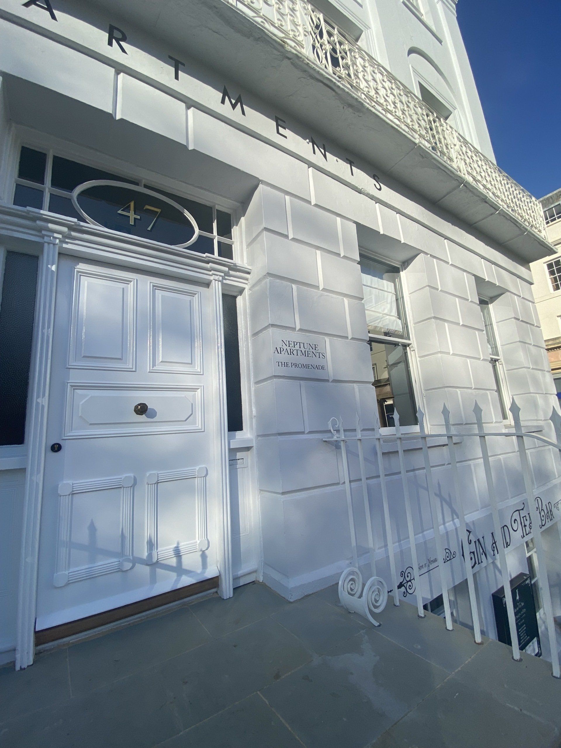 A white building with a white door and a white railing.