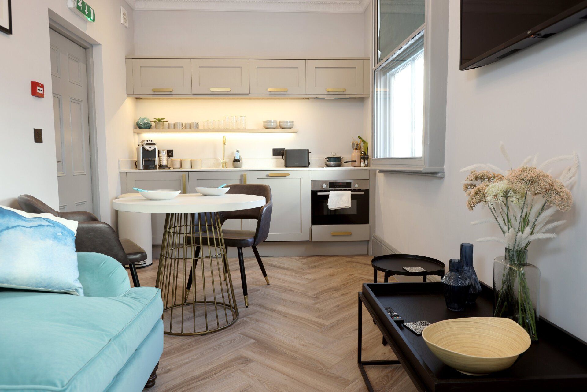 A living room with a couch , table , chairs and a television.