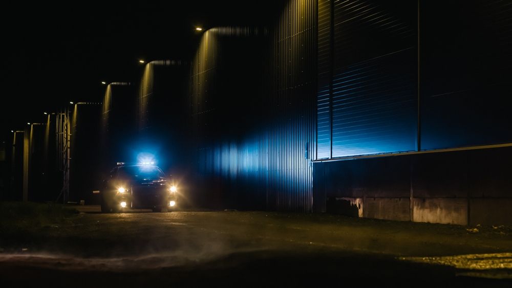 A truck is driving down a dark street at night.