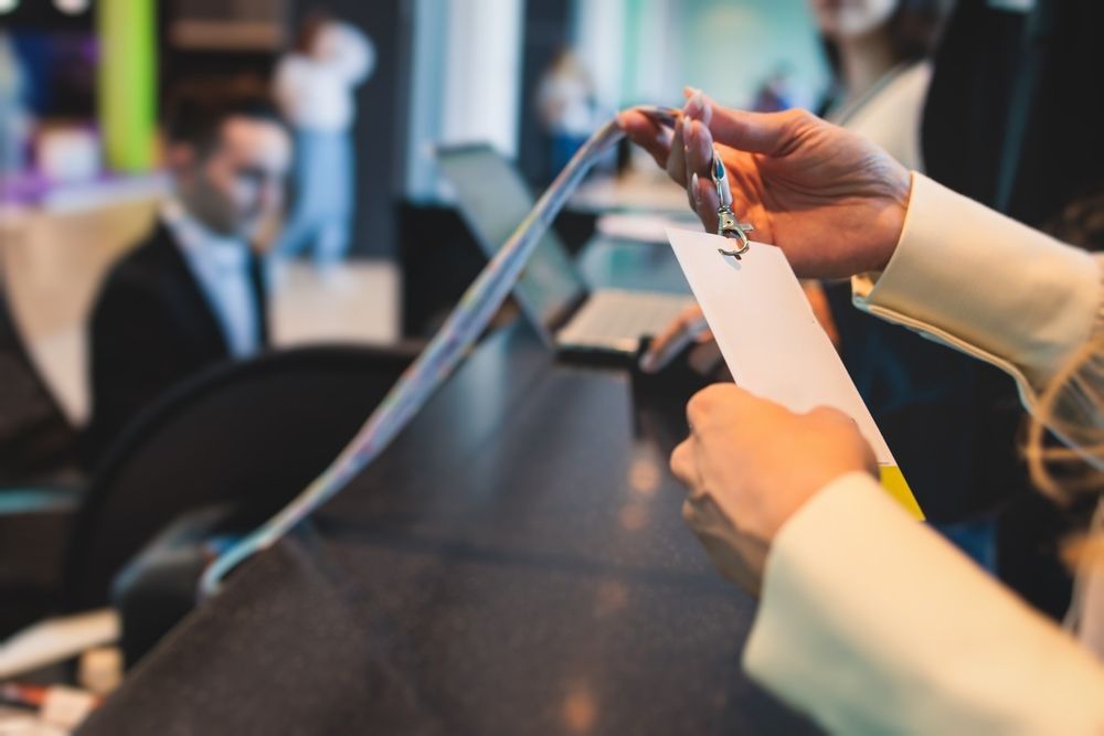 A woman is holding a name tag at a counter.