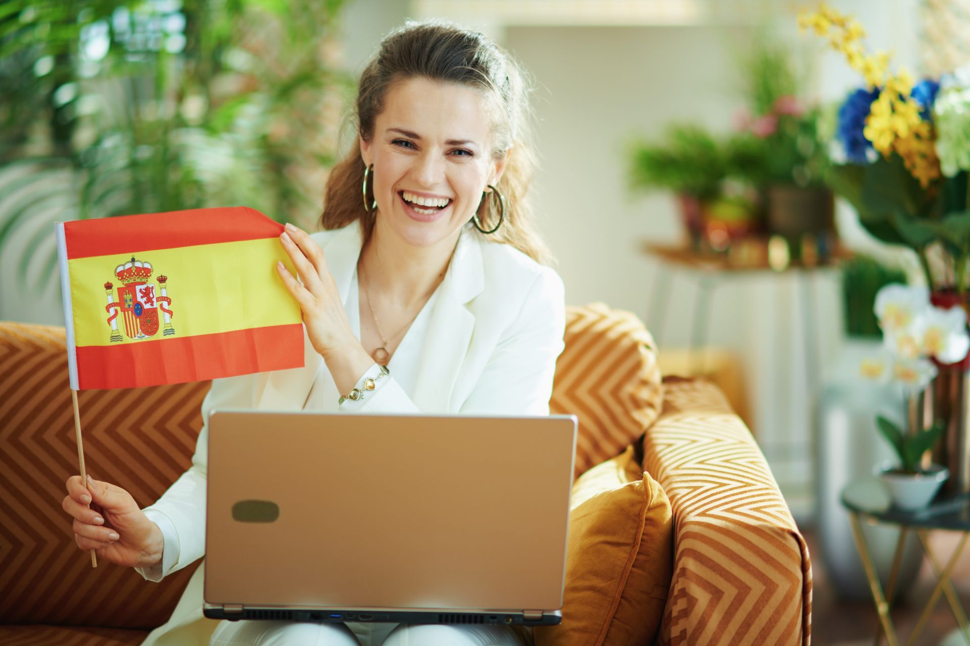 Woman with laptop and showing Spanish flag