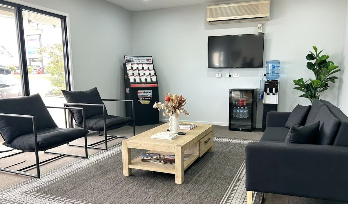 A Living Room With A Couch, Chairs, Coffee Table And Television — Hervey Bay Service Centre in Pialba, QLD