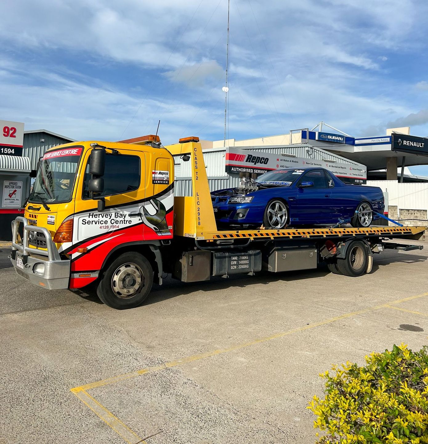 A White Suv Is Sitting On Top Of A Red Lift In A Garage — Hervey Bay Service Centre in Pialba, QLD