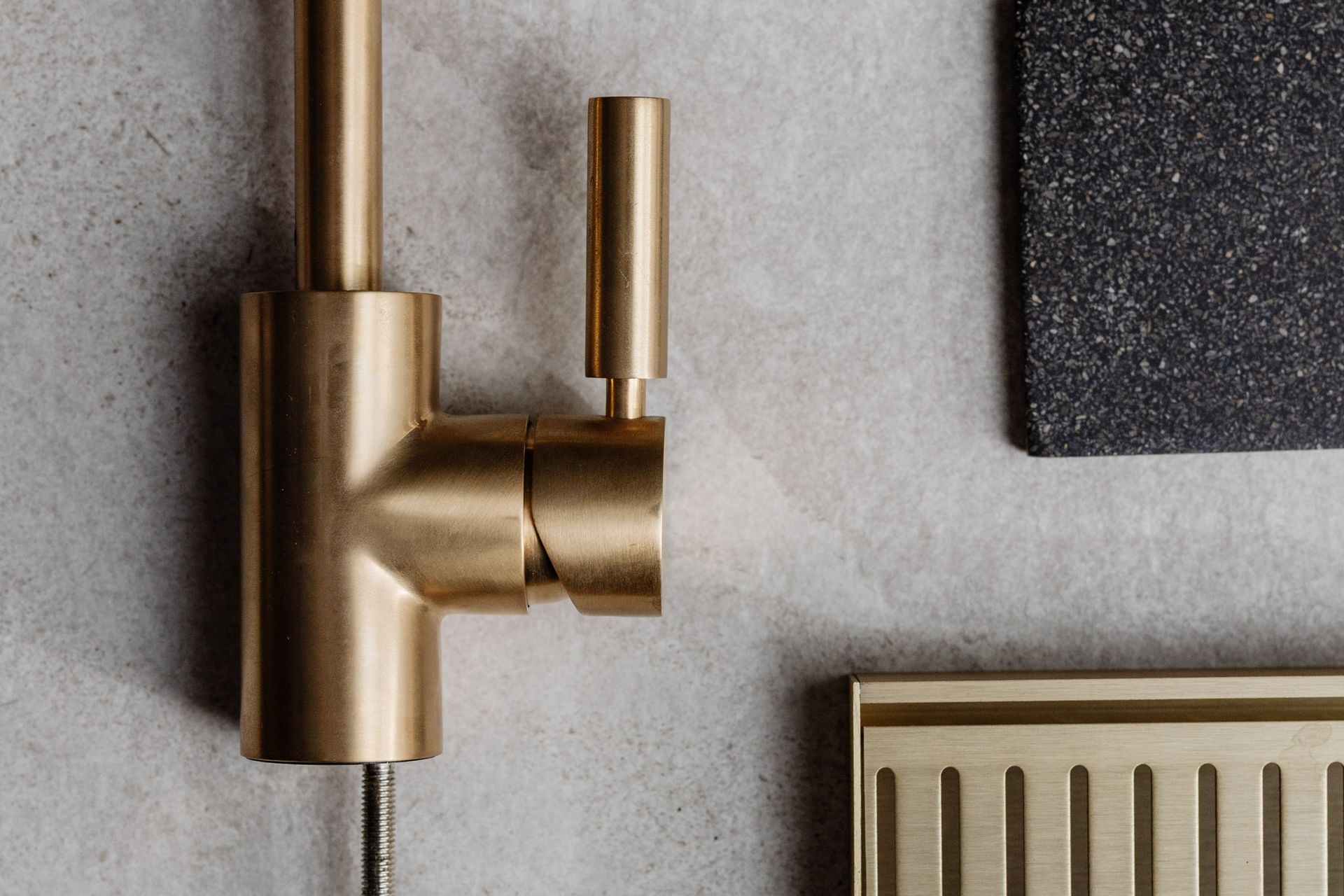 Gold-toned kitchen faucet with handle, part of a kitchen setting.