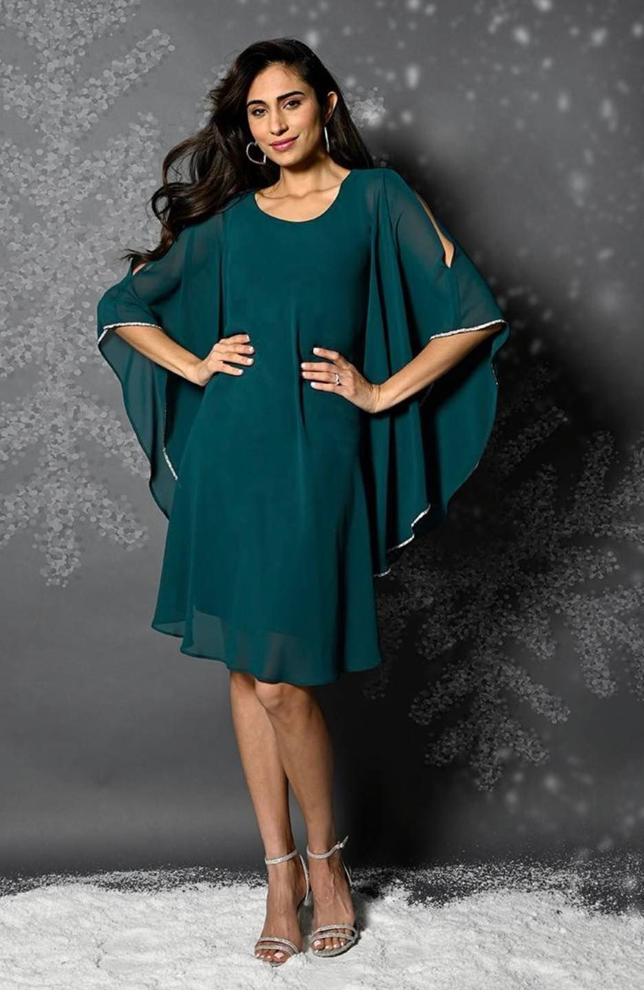 A Woman is Wearing a Green Dress With a Cape on the Sleeves — Onyx Poppy Boutique Buderim in Sunshine Coast, QLD