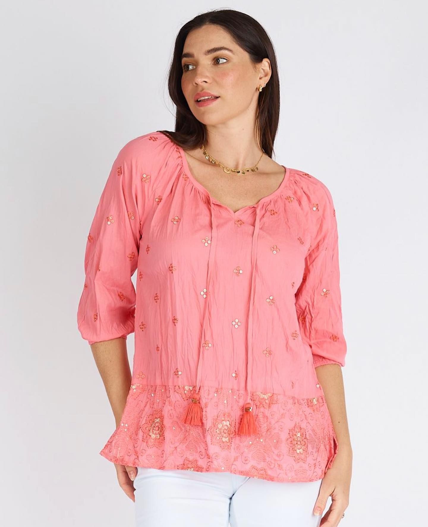 A Woman is Wearing a Pink Top With Tassels and White Pants — Onyx Poppy Boutique Buderim in Sunshine Coast, QLD