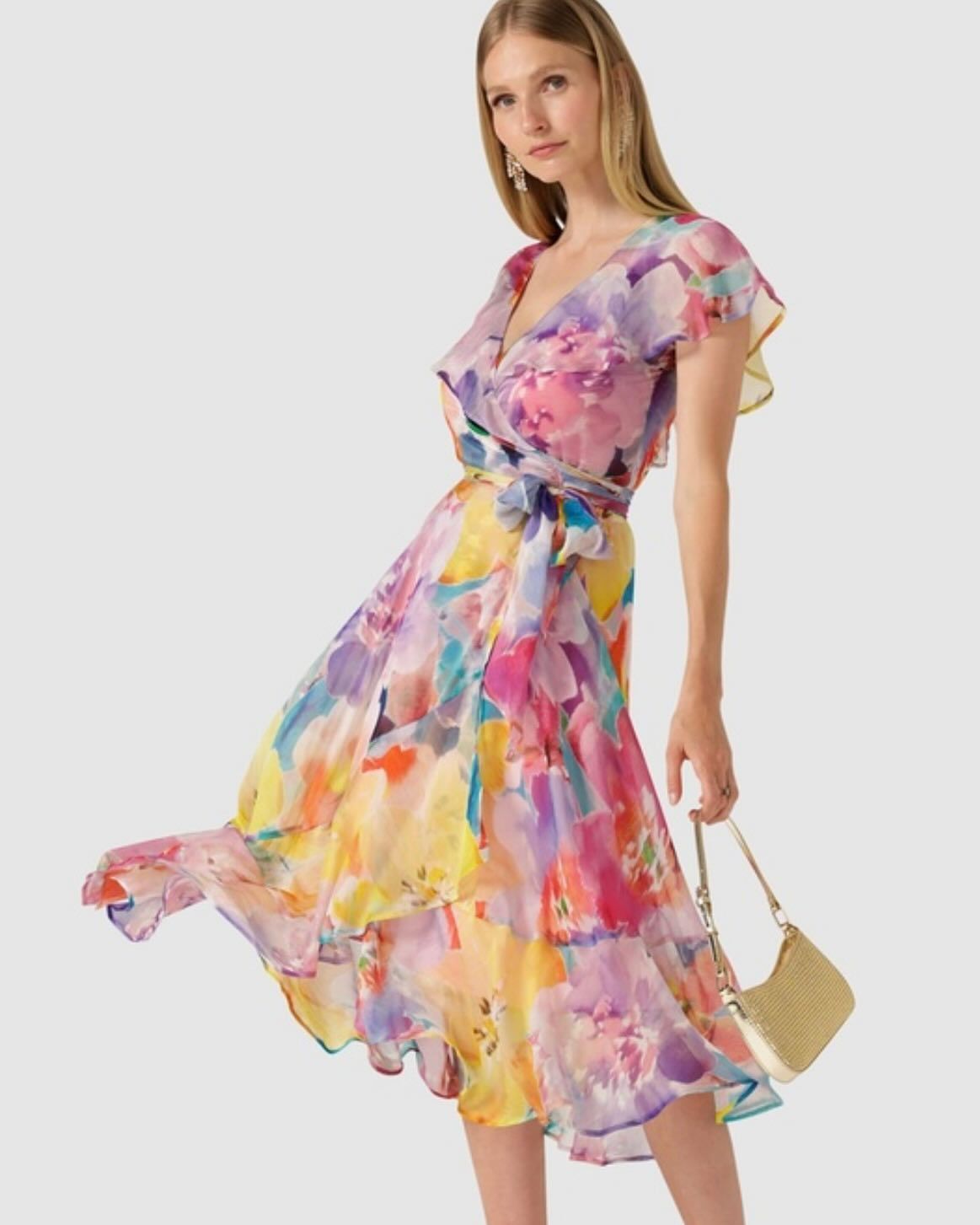 A Woman is Wearing a Colourful Floral Dress and Holding a Purse — Onyx Poppy Boutique in Buderim, QLD
