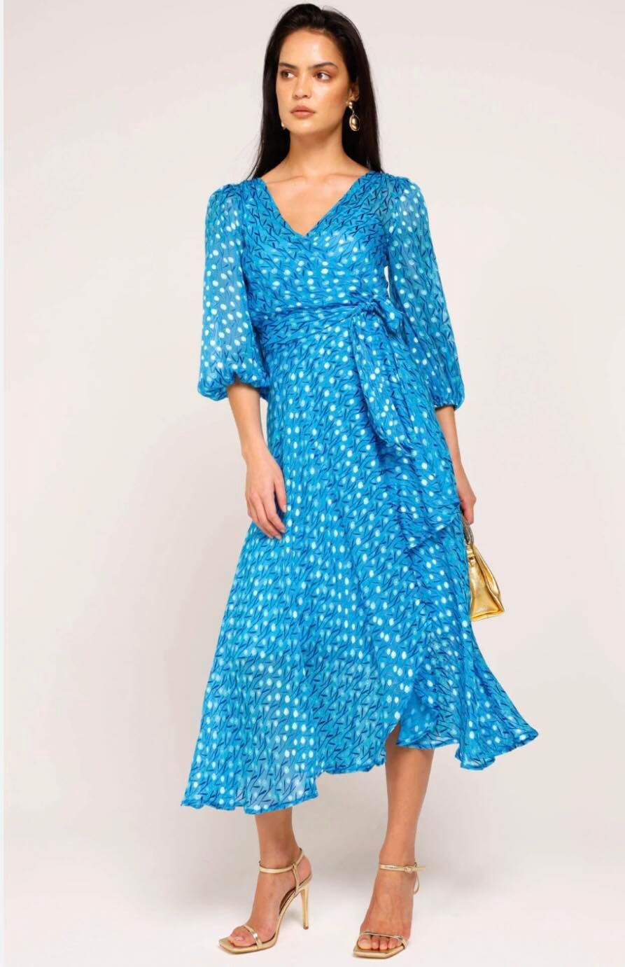 Woman in Blue Patterned Dress with a V-neck, Tied Waist, and Heels, Holding a Gold Bag — Onyx Poppy Boutique in Sunshine Coast, QLD