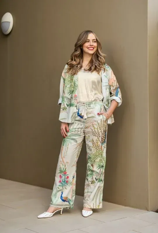 A Woman is Standing in Front of a Wall Wearing a Floral Suit — Onyx Poppy Boutique Buderim in Sunshine Coast, QLD